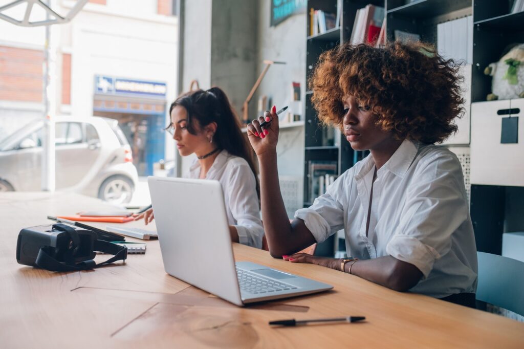 two young multiracial women working on a project in a coworking